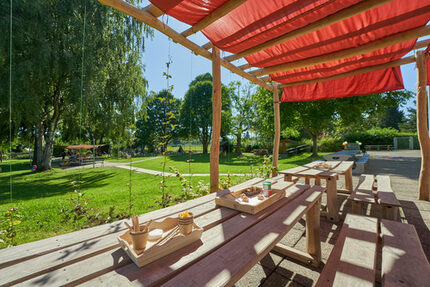 Unter unserer Robinienholz-Pergola können bereits die Kleinsten zu großen Abenteurern werden. Wilde Kiwi und Waldreben zaubern dabei einen grünen Wohlfühlplatz für jede Entdeckerin und jeden Entdecker– natürlich begrünt, natürlich erleben.