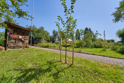 In unserem Schreberino können kleine Gärtner durch Beete streifen, Kräuter schnuppern und ihr eigenes Gemüse wachsen sehen. Gewächshaus, Kräuterschnecke und Apfelbäumchen machen jede Gartenminute zu einem kleinen Abenteuer.