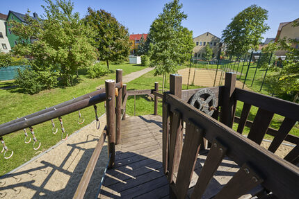 Spielgerüst aus Holz in Schiffform mit einem Ausblick über das große Gartengelände
