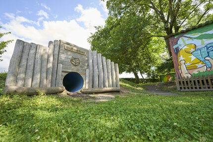 Unser Fuchsbau, der Bauwagen und viele Büsche und Sträucher in unserer Naturecke laden zum Verstecken ein.