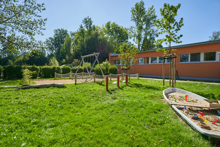 Kleiner Garten mit Fahrzeugstrecke, Schaukel und Sandkastenboot